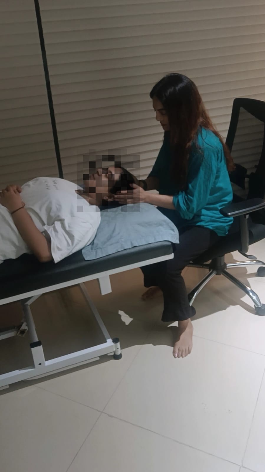 Vibha Jain seated beside a client resting on a therapy couch during a guided regression session